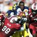 Michigan quarterback Devin Gardner protects the ball as he attempts to muscle through South Carolina defensive ends Devin Taylor and Jadeveon Clowney after loosing his helmet in the second quarter against South Carolina in the Outback Bowl in Tampa, Fla. on Tuesday, Jan. 1. Melanie Maxwell I AnnArbor.com